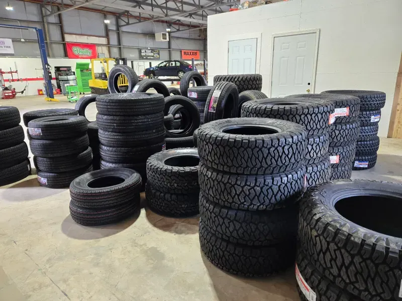 A bunch of tires are stacked on top of each other in a warehouse