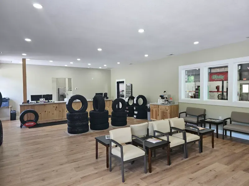 A waiting room with a lot of chairs and tires on the floor.