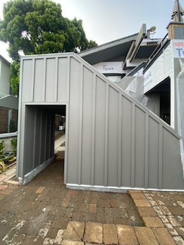 Gray metal stair structure with covered entrance outside a building