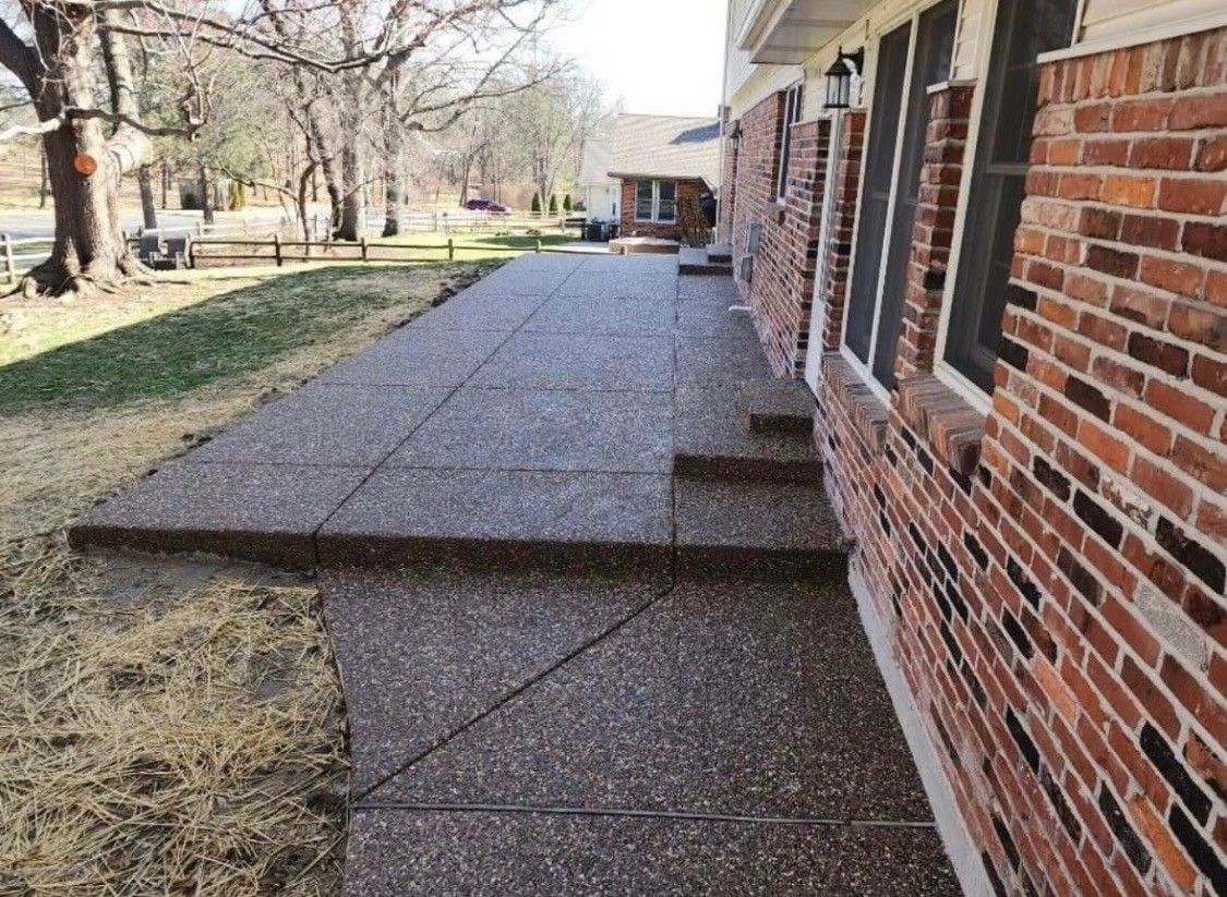 Brick building with a raised concrete walkway and steps along the side yard