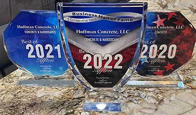 Three blue glass awards on a granite counter, labeled 2020, 2021, and 2022.