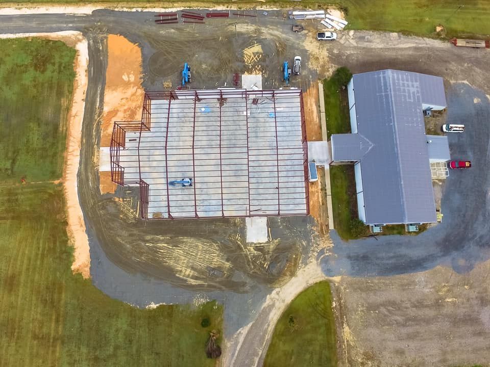 An aerial view of a building under construction in a field.