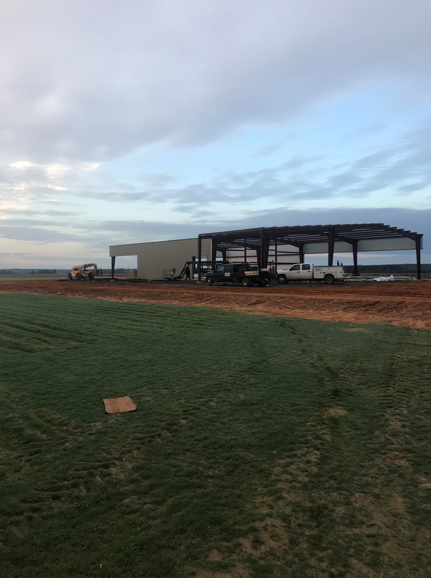 A large building is being built in the middle of a field.