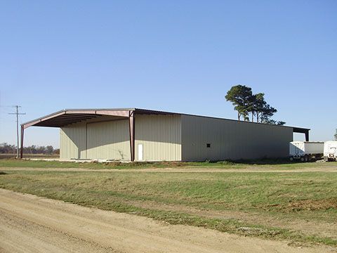 A large building is sitting in the middle of a grassy field.