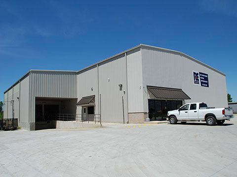 A white truck is parked in front of a large building.