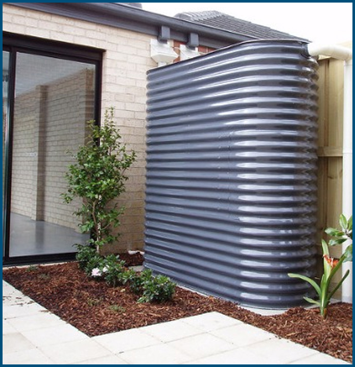 A gray water tank is next to a brick house
