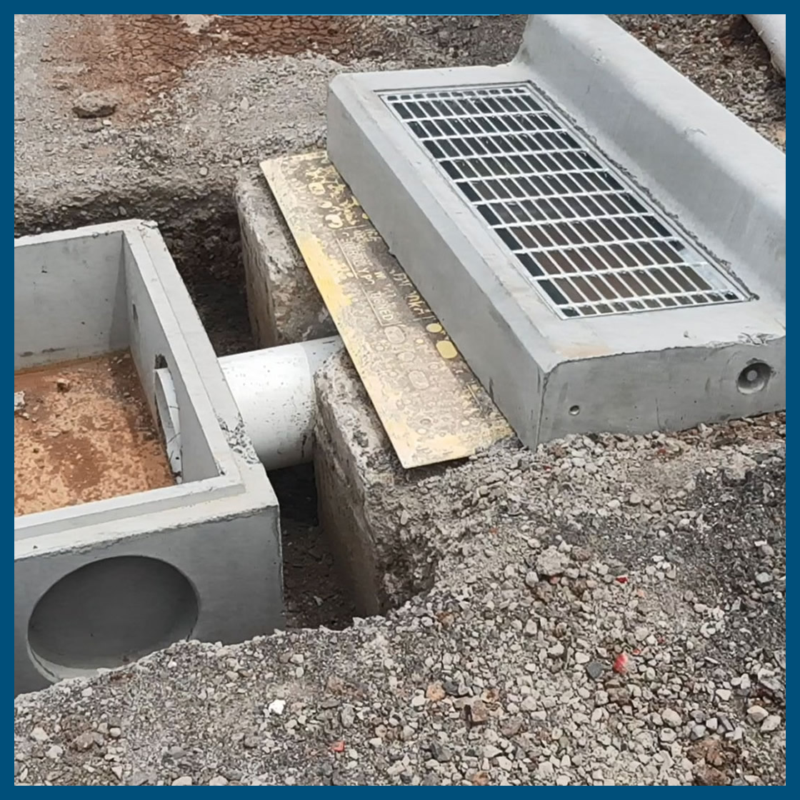 A metal grate is sitting on top of a concrete box.