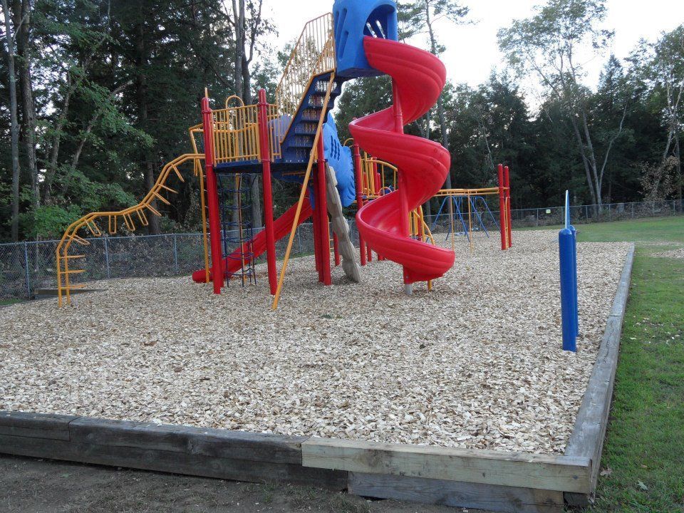 A playground with a red and blue spiral slide