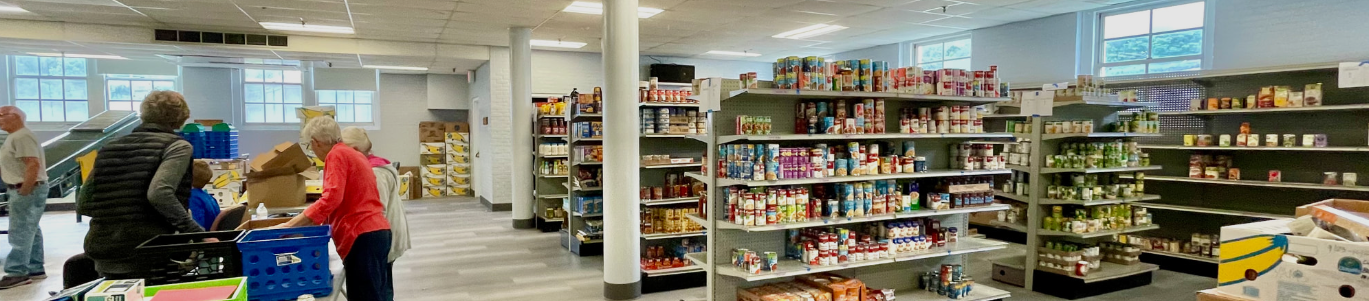 Bright grocery store aisle with shoppers near blue carts and shelves of snacks and pantry items