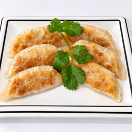Plate of golden fried dumplings garnished with fresh cilantro on a white plate