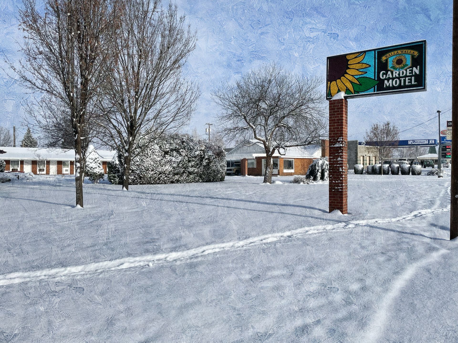 A sign for the garden hotel is in the snow