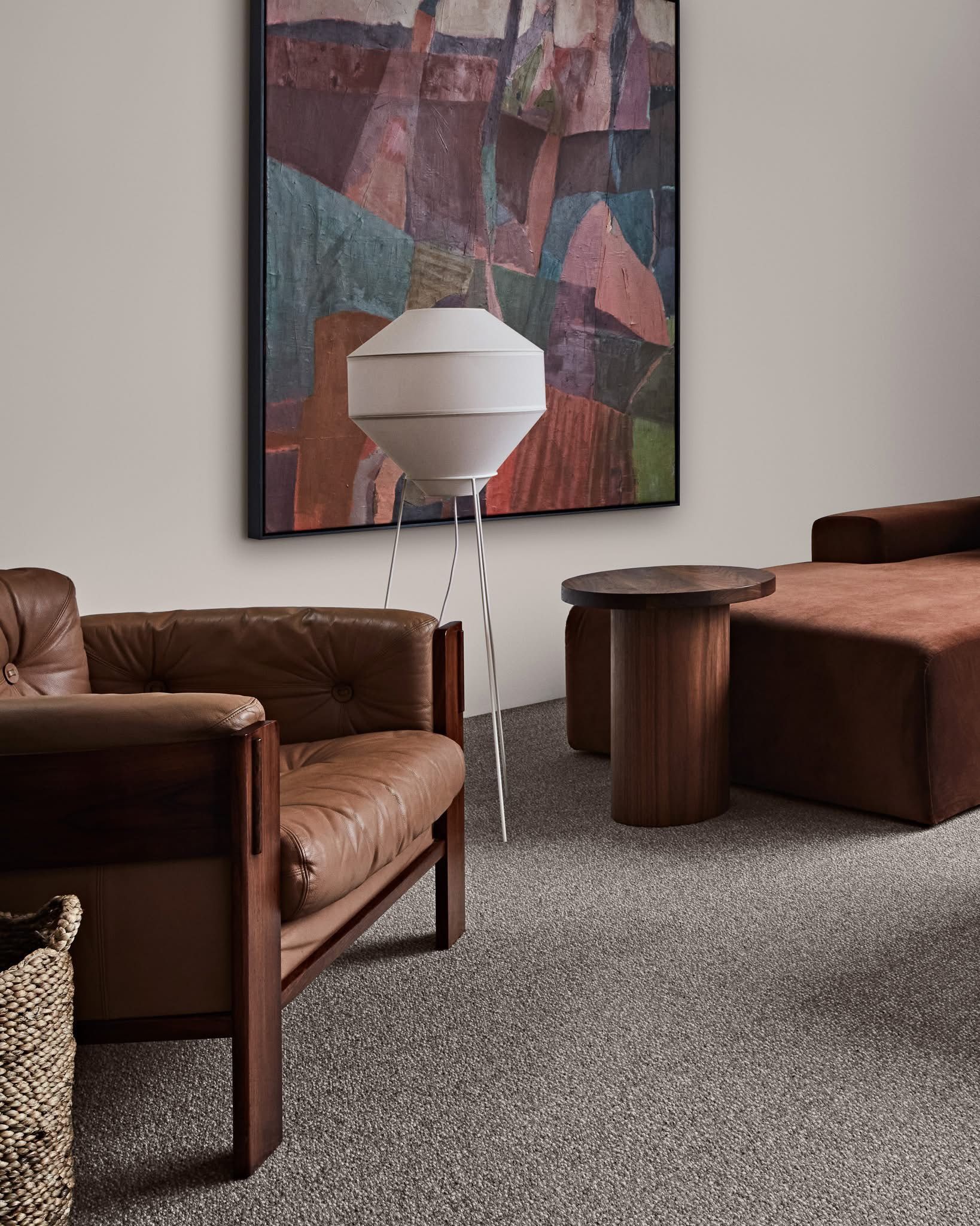 Woman in beige outfit leans against shelves, reading in a light, neutral-toned room — Kelwin Coastal Carpets In Kundra Park, QLD