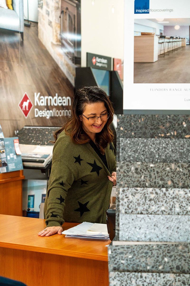 A Woman Is Standing at A Counter in A Store — Kelwin Coastal Carpets In Kundra Park, QLD
