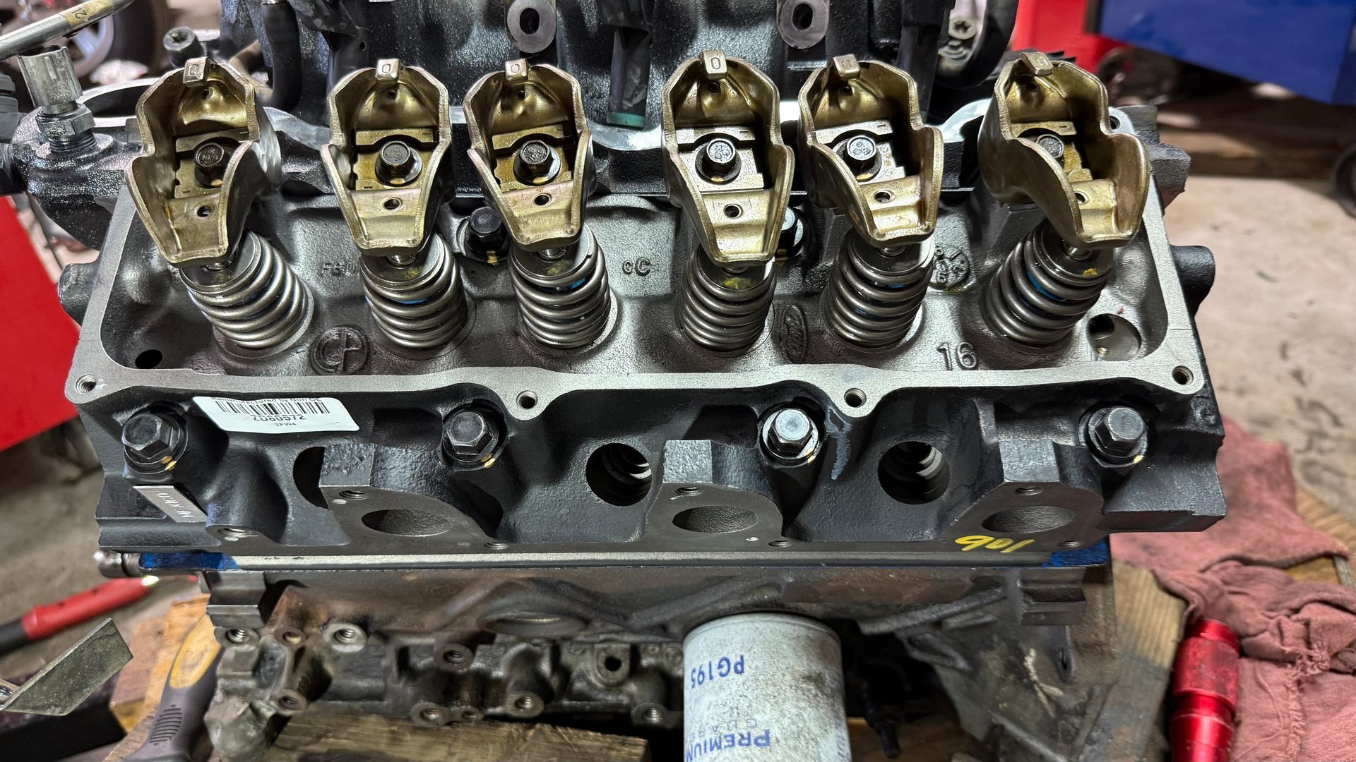 Engine cylinder head with rocker arms, bolts, and valves exposed. | Alberto's Transmissions & Auto