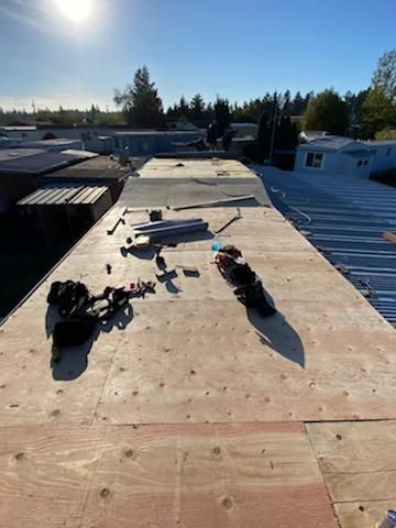 Roof under construction with tools and plywood sheets in bright sunlight