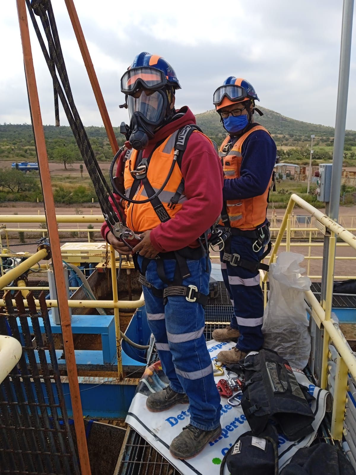 Un hombre que lleva una máscara de gas está de pie en lo alto de una escalera.