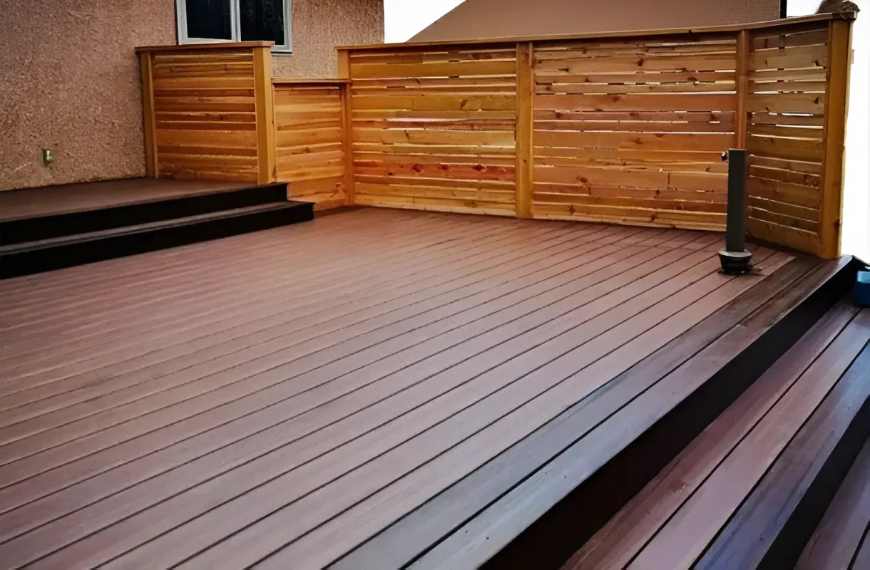 Wooden backyard deck with horizontal fence panels and steps, empty and clean.