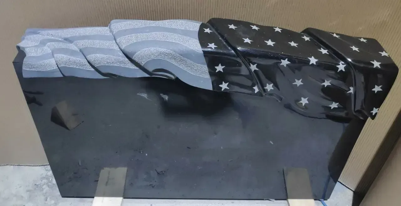 A dark, rectangular object with a blue and star-covered fabric draped over it.