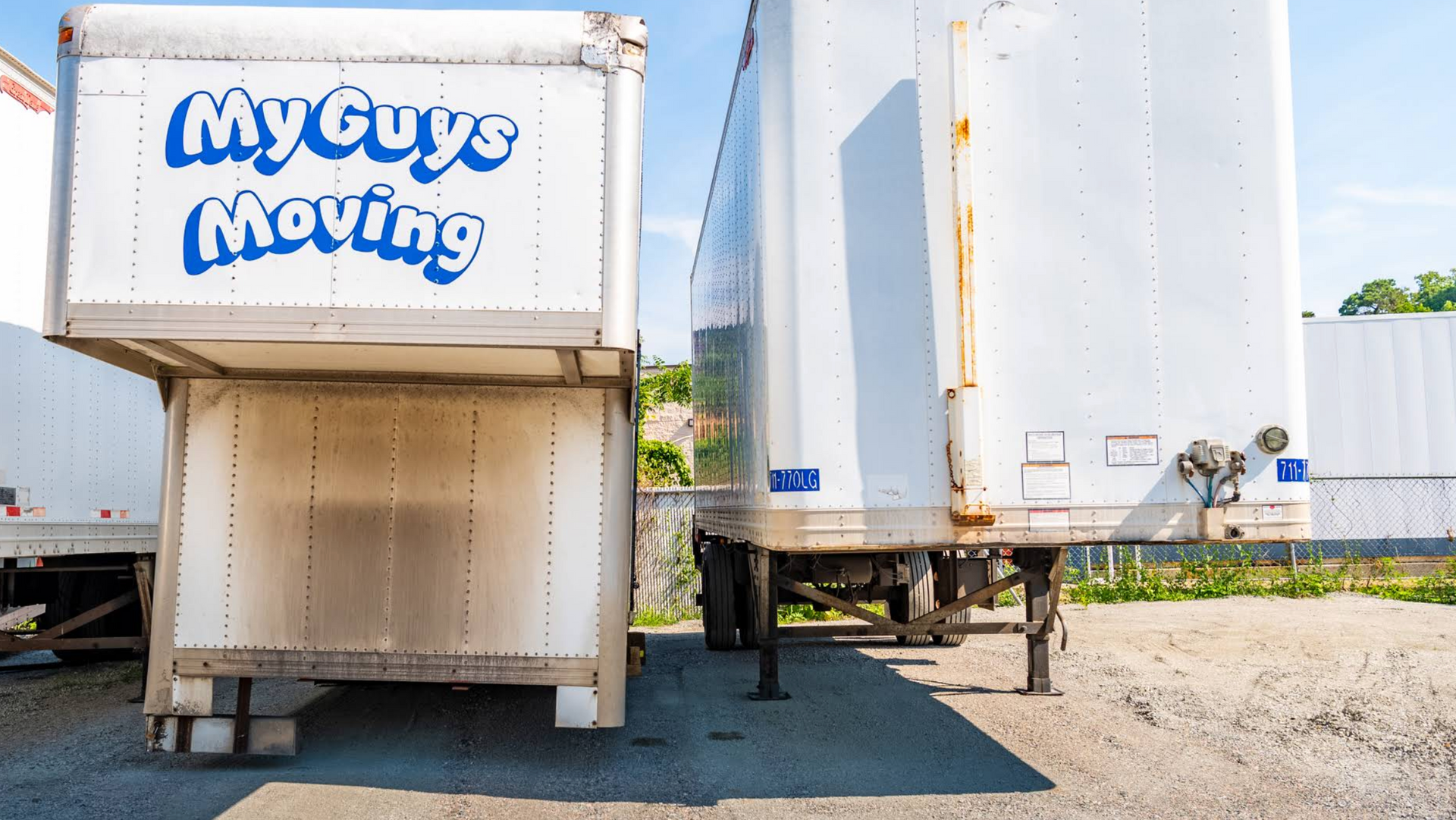 My Guys Moving box truck beside a white semi trailer in a sunny lot