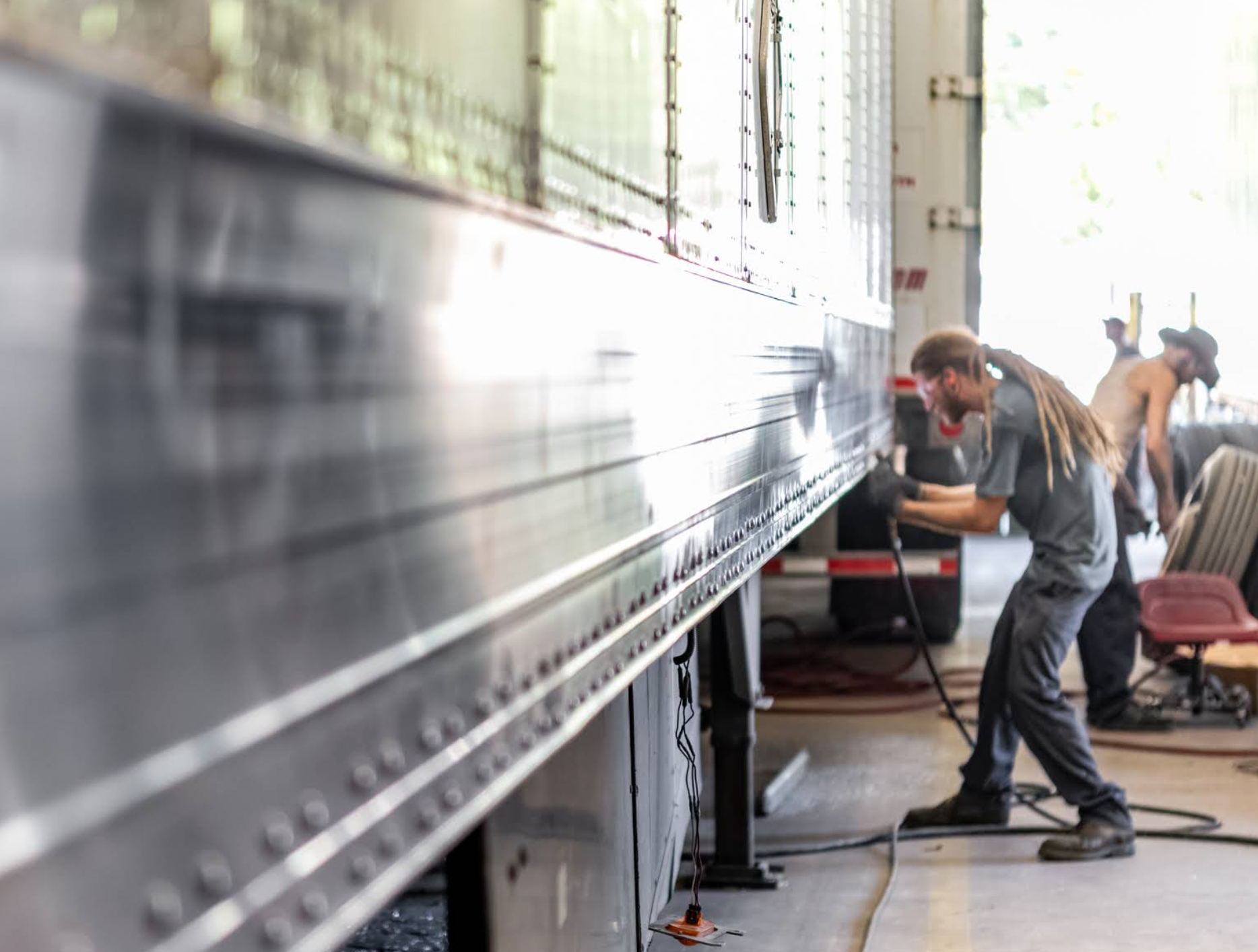 Worker operating a large industrial machine in a bright factory workshop