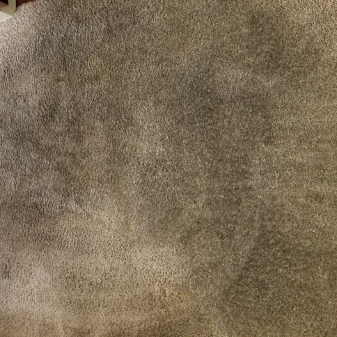 Close-up of a brown and beige textured surface, resembling carpet or fabric.
