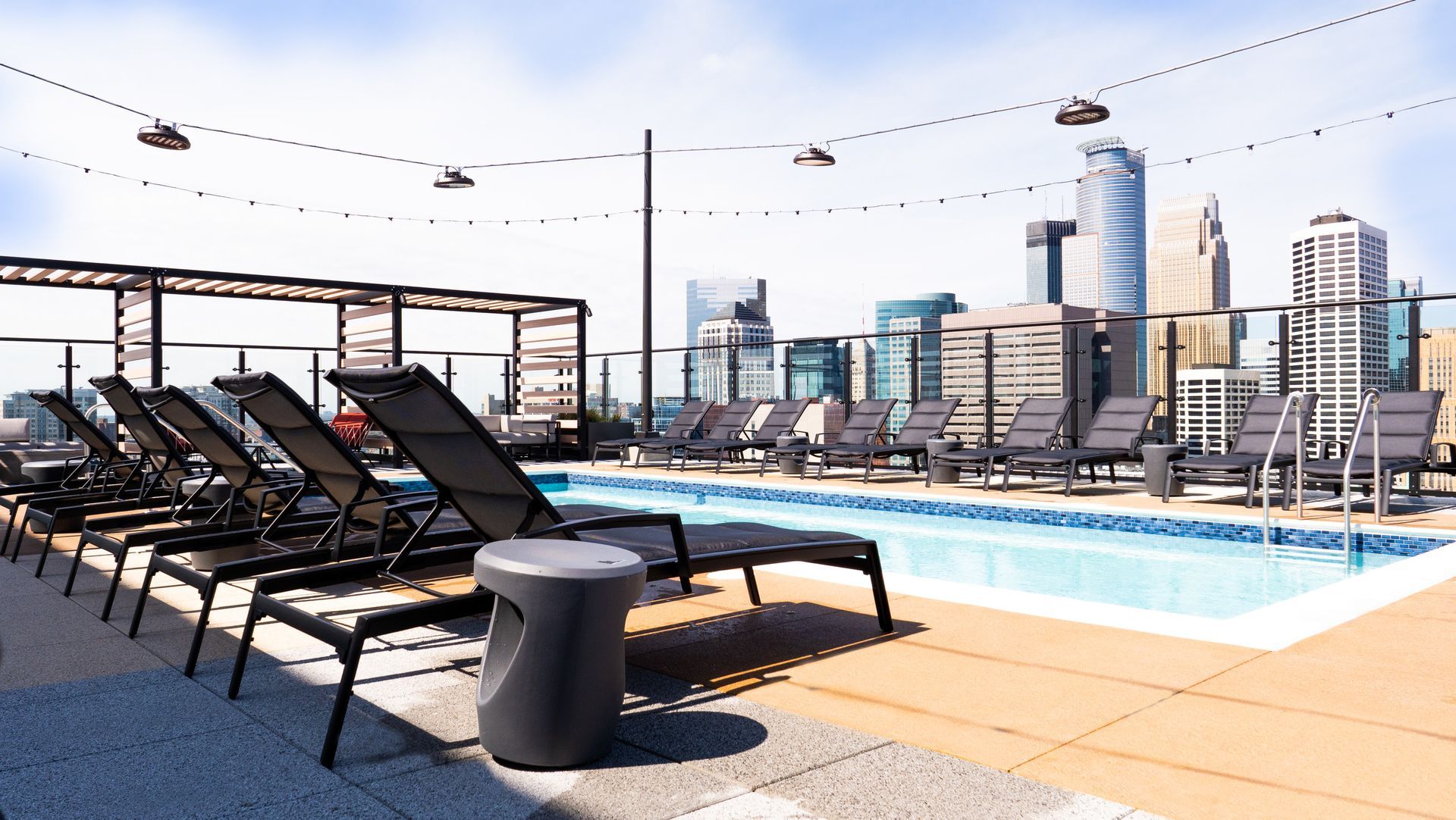 4th and Park large swimming pool surrounded by chairs and a city skyline