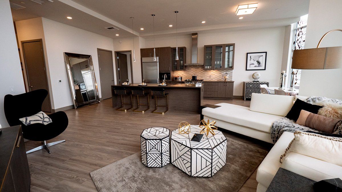 4th and Park living room with a couch , chair , coffee table and kitchen.