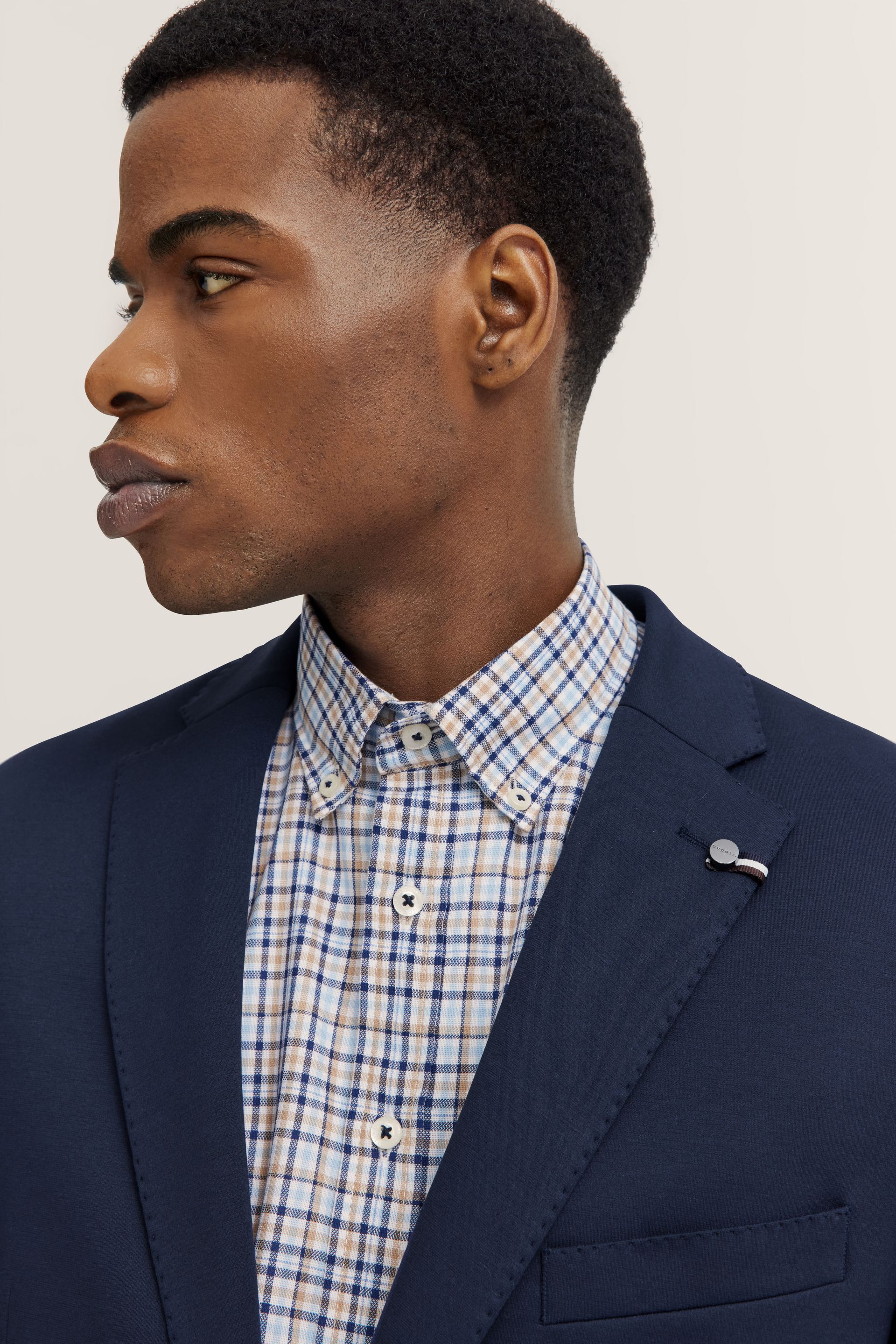 Un uomo che indossa una giacca blu e una camicia a quadri