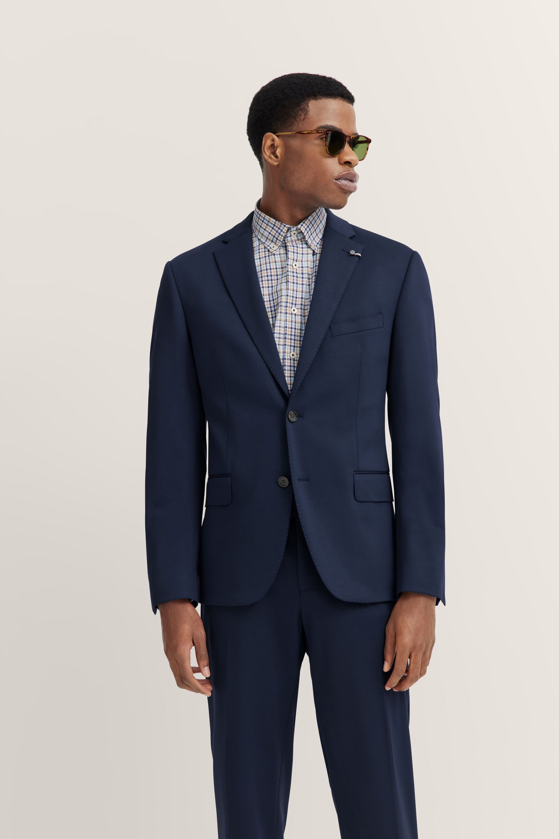 Un uomo indossa un abito blu e occhiali da sole.