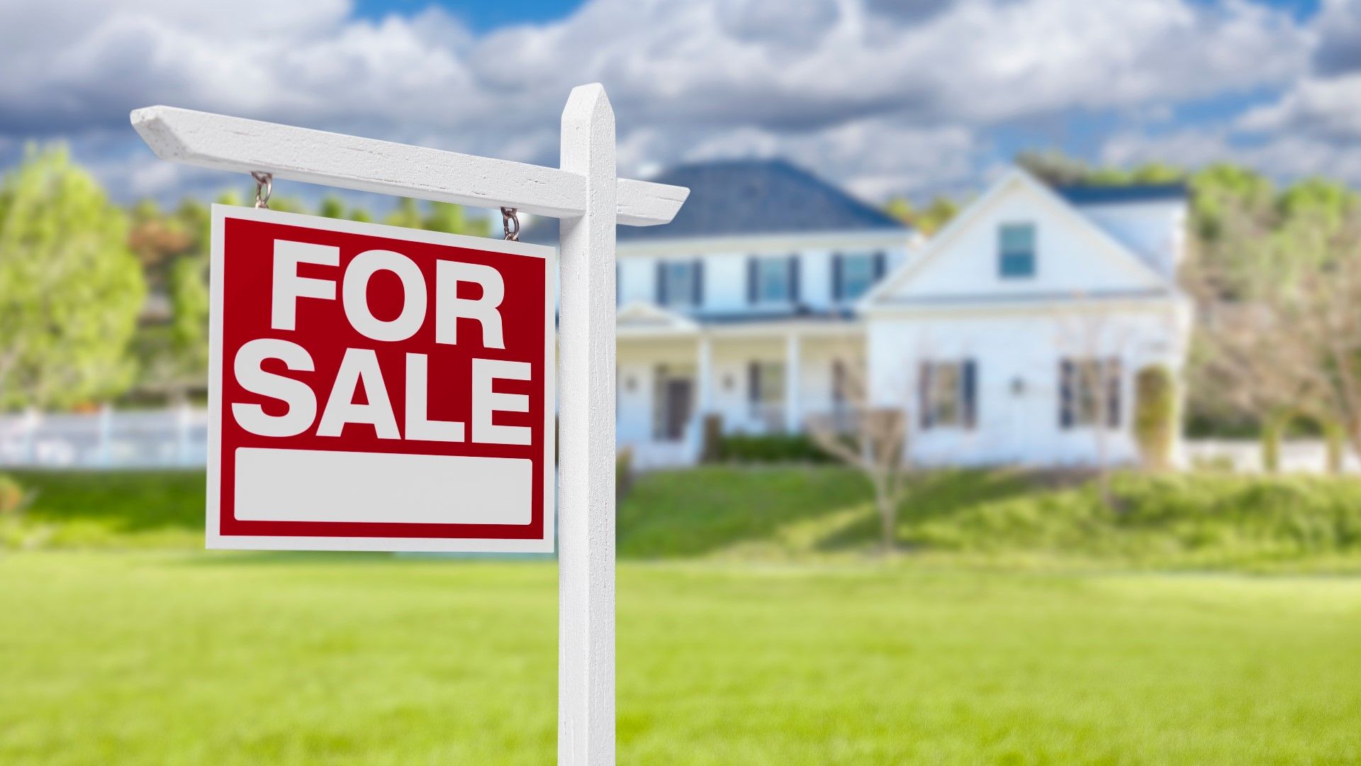 A for sale sign is in front of a house.