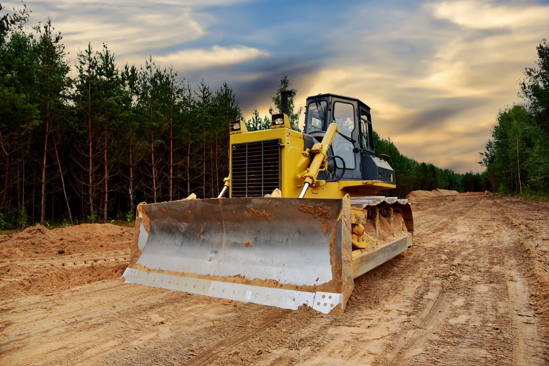 A bulldozer is working on a dirt road