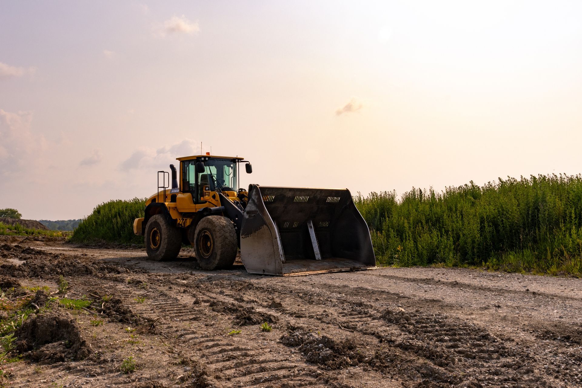 A yellow bulldozer is sitting on top of a dirt field.