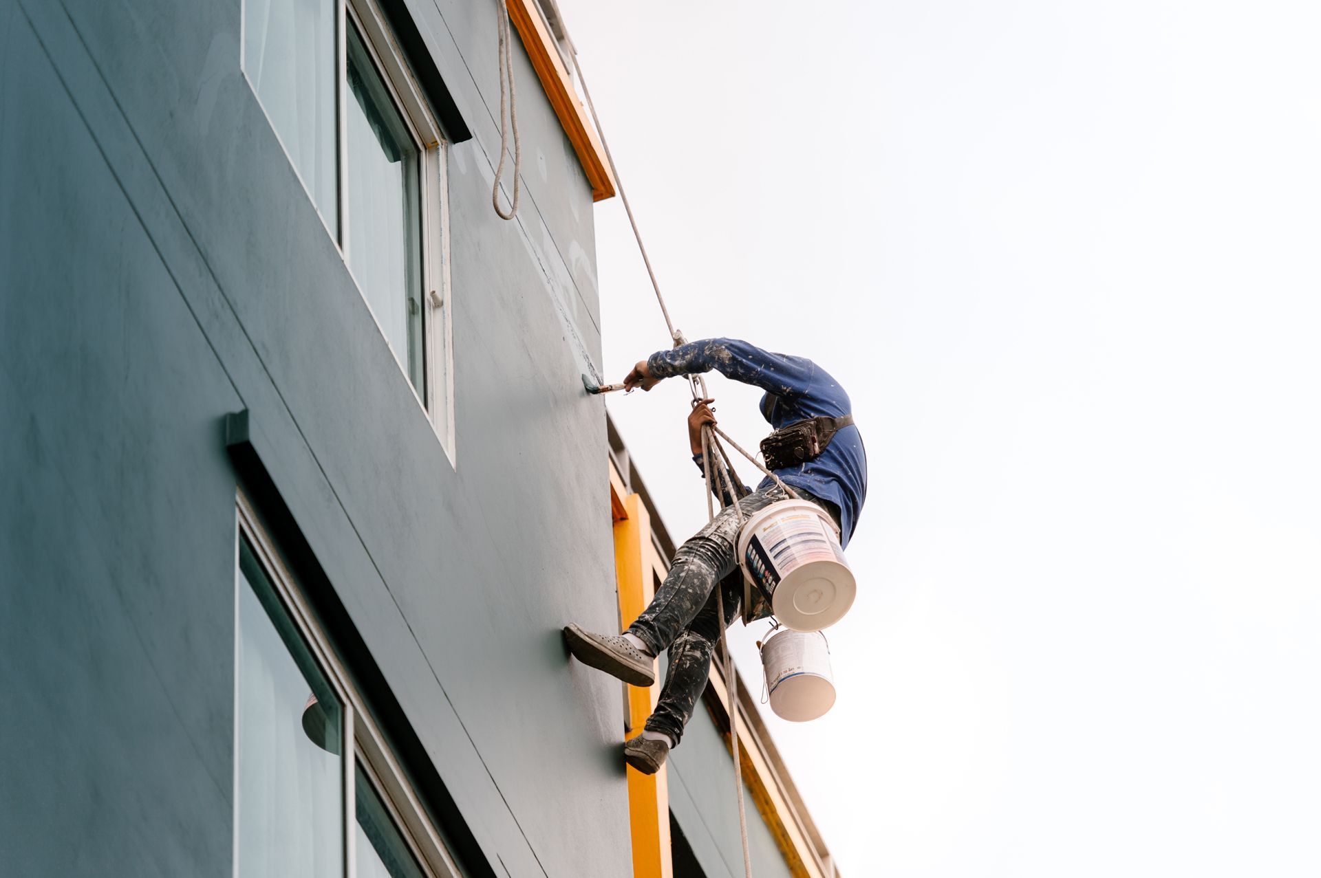 Male Worker Painting a Building Wall