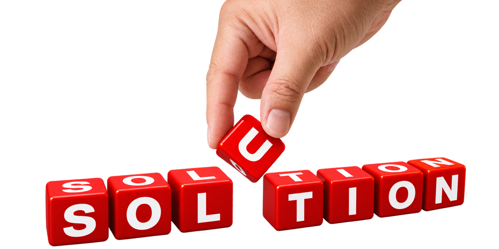 Hand placing a red block to complete the word “SOLUTION” in red letter tiles