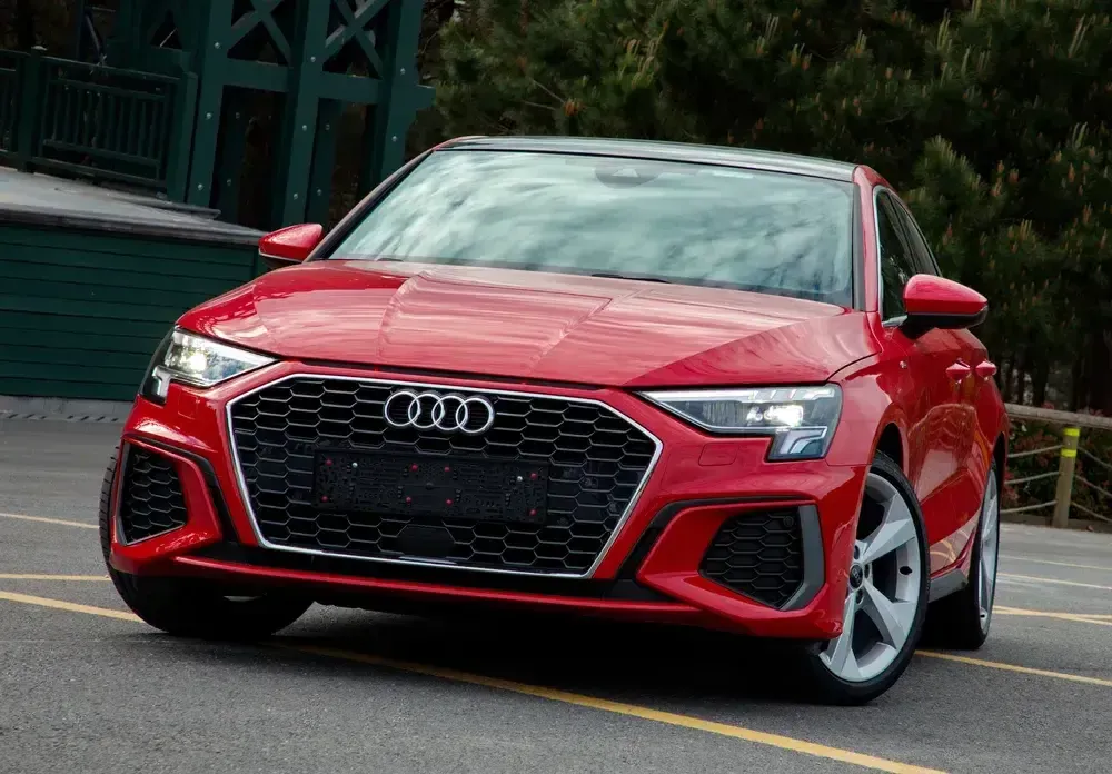 Red Audi SUV parked on a street, front three-quarter view