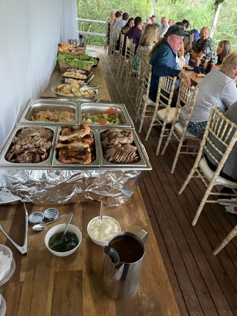 A Group Of People Are Sitting At Tables Eating Food From A Buffet — Tru Blu Catering In Port Macquarie, NSW