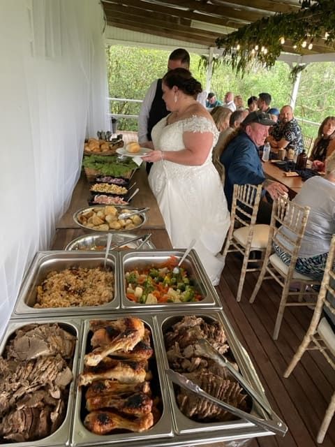 A Bride Is Standing In Front Of A Buffet Line At A Wedding Reception — Tru Blu Catering In Port Macquarie, NSW