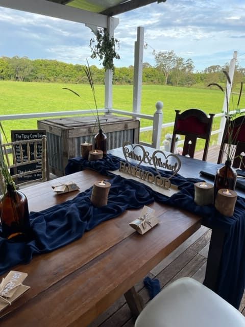 A Wooden Table With A Blue Table Runner And Candles On It — Tru Blu Catering In Port Macquarie, NSW
