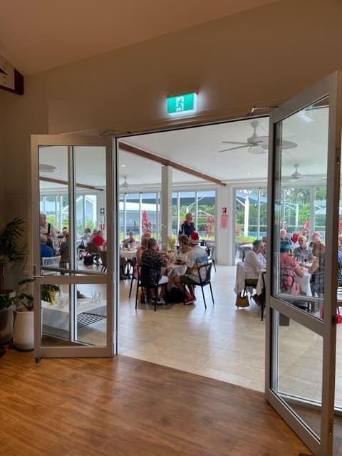 A Group Of People Are Sitting At Tables In A Large Room — Tru Blu Catering In Lake Cathie, NSW