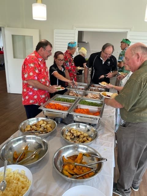 A Group Of People Are Standing Around A Buffet Table With Bowls Of Food — Tru Blu Catering In Lake Cathie, NSW