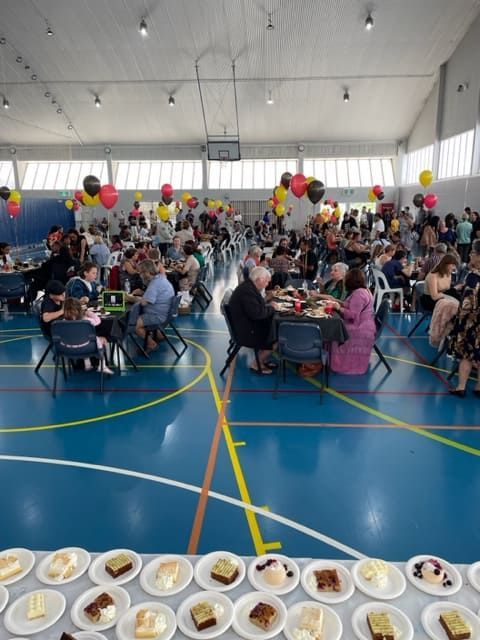 A Large Group Of People Are Sitting At Tables In A Gym — Tru Blu Catering In Woolgoolga, NSW
