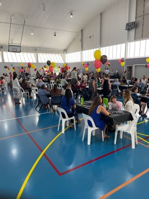 A Large Group Of People Are Sitting At Tables In A Gym — Tru Blu Catering In Woolgoolga, NSW