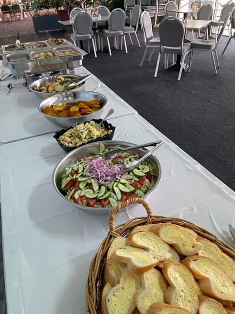 A Buffet Table With Bowls Of Food And A Basket Of Garlic Bread — Tru Blu Catering In Laurieton, NSW