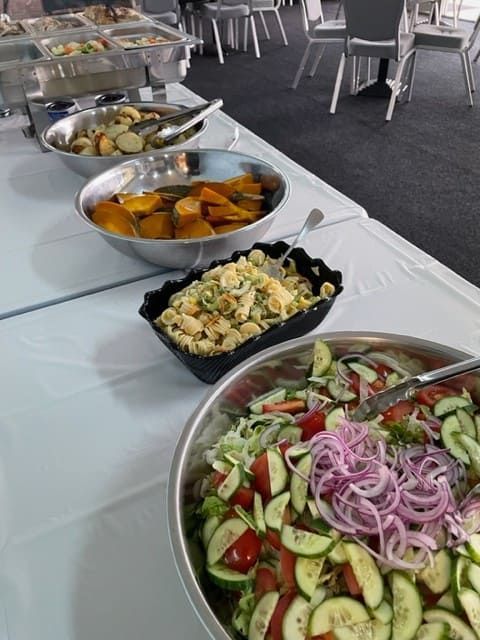 Several Bowls Of Food Are On A Table Including A Salad — Tru Blu Catering In Laurieton, NSW