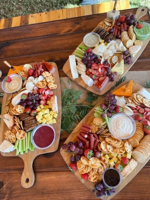Three Wooden Cutting Boards Filled With Different Types Of Food On A Wooden Table — Tru Blu Catering In Nambucca, NSW
