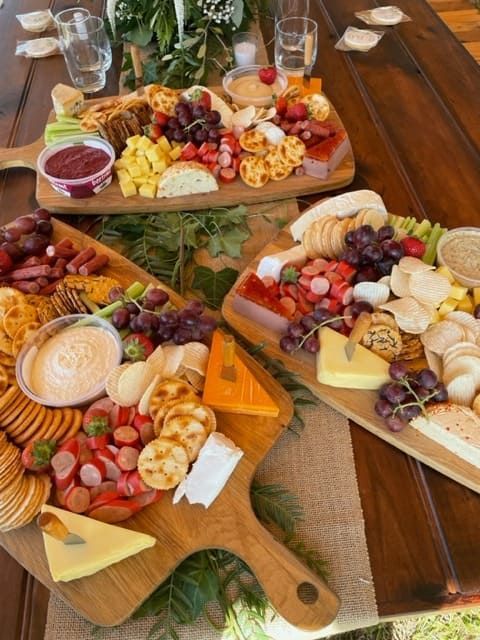 Three Wooden Cutting Boards Filled With Different Types Of Food On A Wooden Table — Tru Blu Catering In Nambucca, NSW