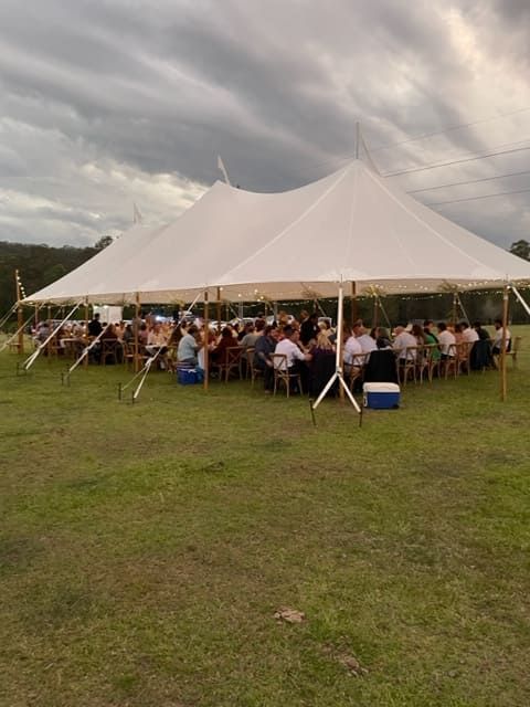 A Group Of People Are Sitting Under A Tent In A Field — Tru Blu Catering In Wauchope, NSW
