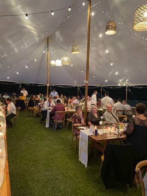 A Group Of People Are Sitting At Tables Under A Tent — Tru Blu Catering In Wauchope, NSW