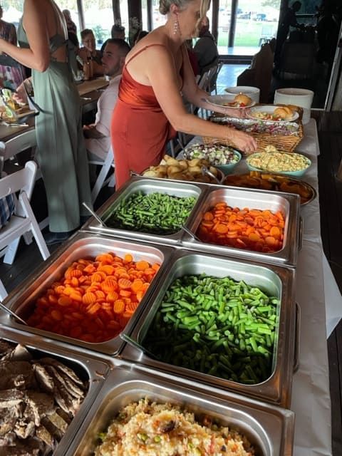 A Woman Is Standing In Front Of A Buffet Table Filled With Vegetables — Tru Blu Catering In Taree, NSW