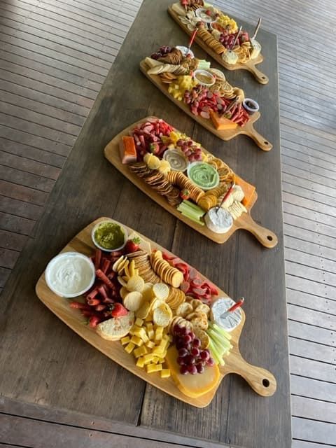 Three Wooden Cutting Boards Filled With Food On A Wooden Table — Tru Blu Catering In Kempsey, NSW